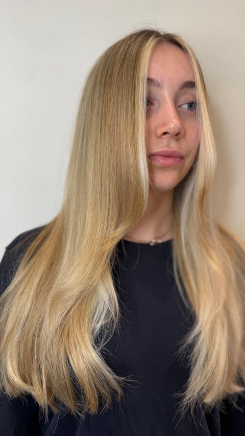 Woman with long blonde hair looking downward